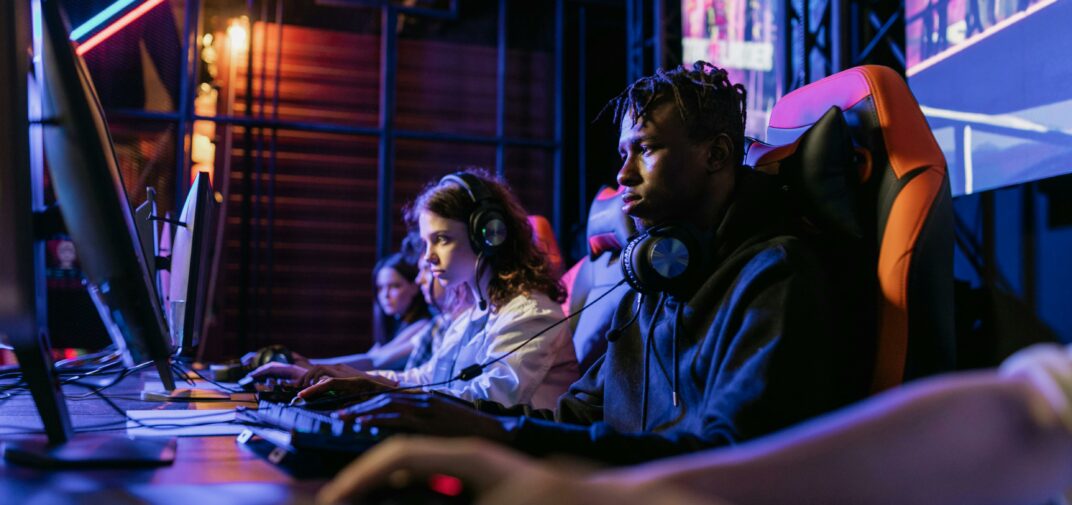 People Sitting on Black and Orange Gaming Chairs